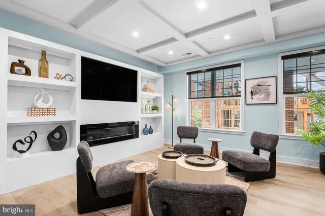 a living room with furniture a flat screen tv and a large window