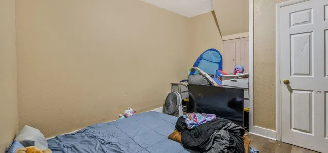 a bedroom with a bed and wooden floor