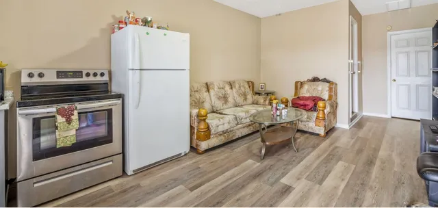 a living room with furniture and a refrigerator