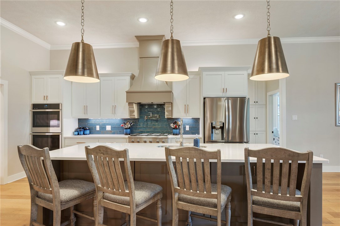 4804 Crystal Ridge Court College Station, TX 77845 - Photo 15 of 48 a kitchen with stainless steel appliances granite countertop a stove a refrigerator a kitchen island a dining table and chairs
