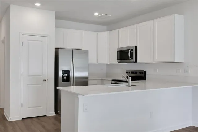 a kitchen with stainless steel appliances a refrigerator a stove a microwave and cabinets