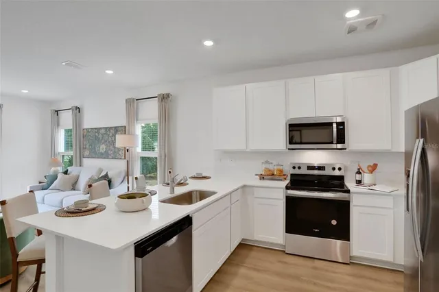 a kitchen with stainless steel appliances a sink a stove top oven a counter space and cabinets