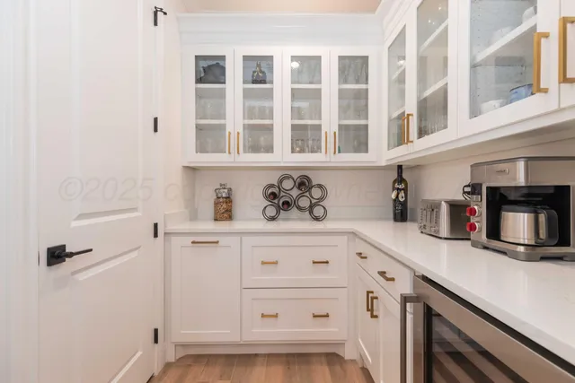 a spacious bedroom with a bed and a lamp on dresser