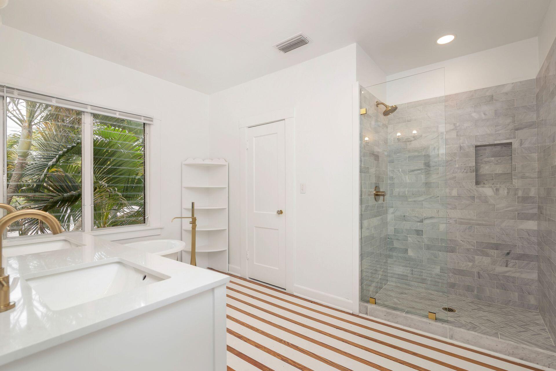 232 Rugby Road West Palm Beach, FL 33405 - Photo 14 of 40 a bathroom with a sink a large mirror and a shower