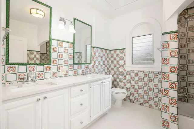 a bathroom with a double vanity sink toilet and a mirror