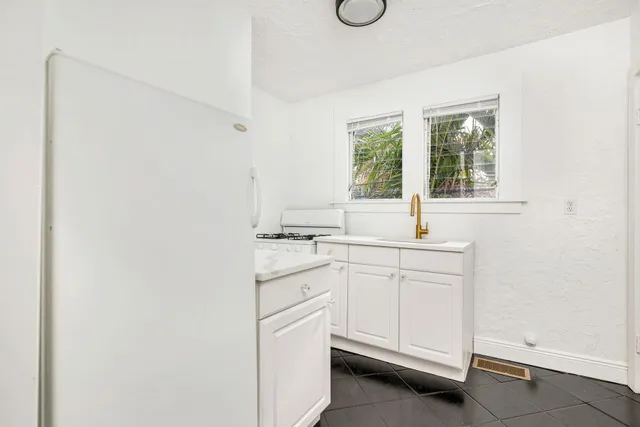 a kitchen with white cabinets and white appliances