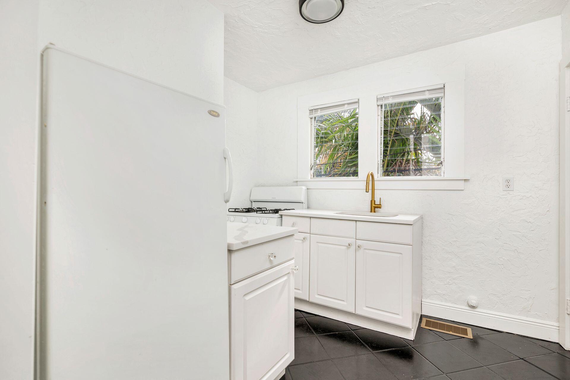 232 Rugby Road West Palm Beach, FL 33405 - Photo 21 of 40 a kitchen with white cabinets and white appliances