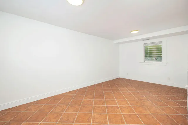 an empty room with a white wall and a window