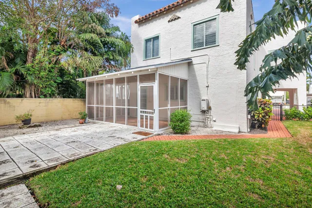 front view of a house with a yard and potted plants