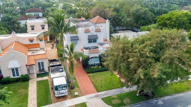 an aerial view of residential houses with outdoor space and trees