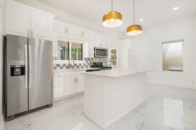 a kitchen with white cabinets and stainless steel appliances