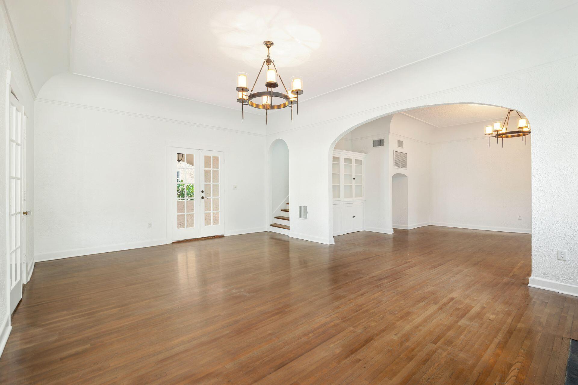 232 Rugby Road West Palm Beach, FL 33405 - Photo 5 of 40 a view of an empty room with wooden floor and a chandelier