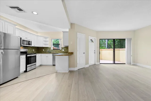 a kitchen with granite countertop white cabinets and white appliances