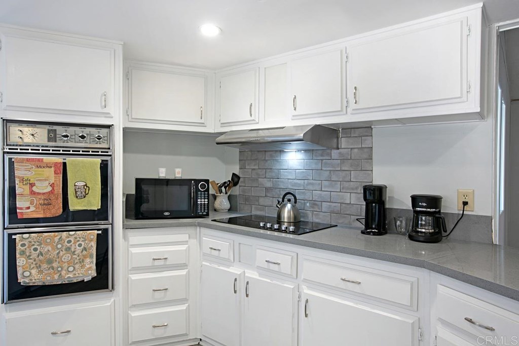 2250 North Broadway, Unit 10 Escondido, CA 92026 - Photo 10 of 30 A close-up of the new electric cooktop, hood, and decorative tile backsplash.