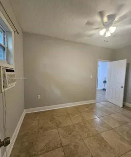 wooden floor in an empty room with a bathroom