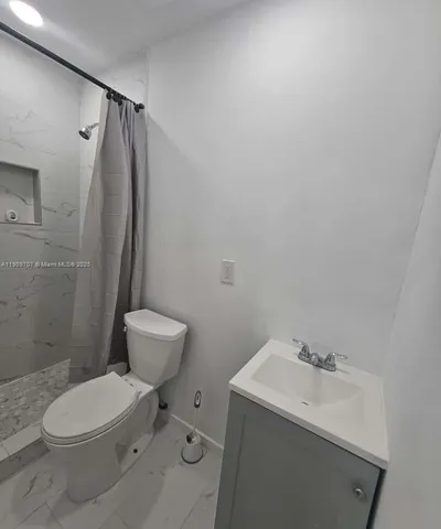 a bathroom with a toilet a sink and a mirror