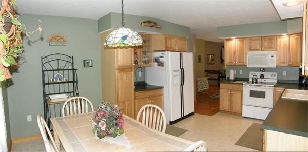 111 Pierpont Road Dudley, MA 01571 - Photo 7 of 30 a kitchen with stainless steel appliances granite countertop a refrigerator a stove a sink dishwasher and a dining table with wooden floor