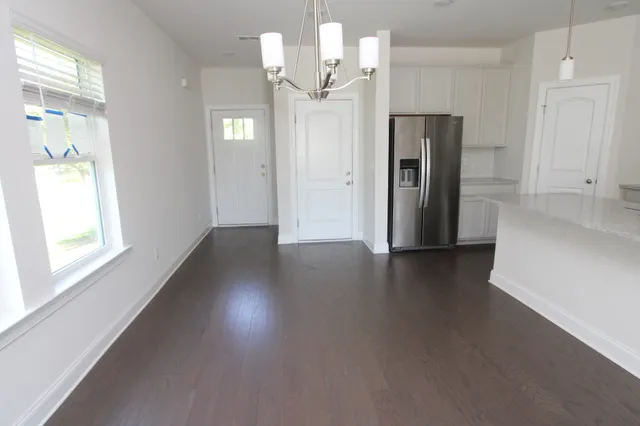 a view of a kitchen with a white cabinet and wooden floor