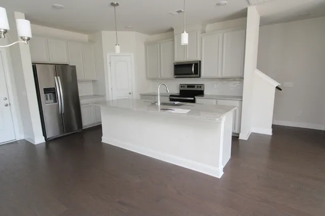 a kitchen with stainless steel appliances a microwave a sink a refrigerator a stove a microwave and cabinets