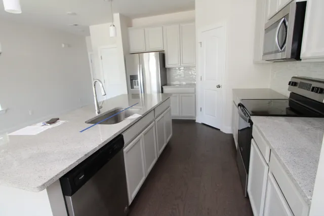 a kitchen with stainless steel appliances granite countertop a sink stove and refrigerator