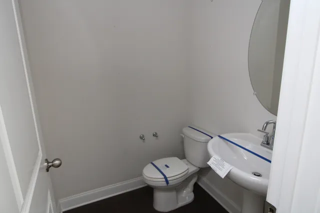 a white toilet sitting next to a white sink and vanity