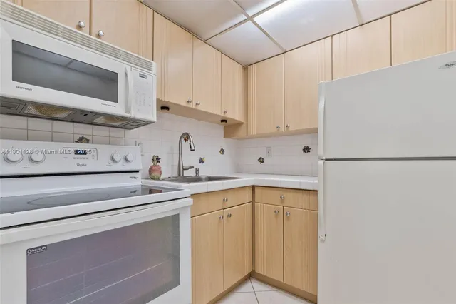 a kitchen with stainless steel appliances white cabinets and a refrigerator
