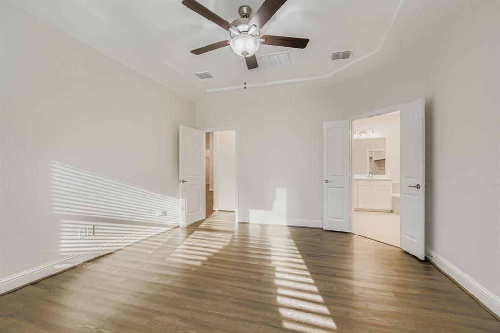312 Magnolia Drive Oak Point, TX 75068 - Photo 13 of 28 Unfurnished bedroom with wood finished floors, ceiling fan, and connected bathroom