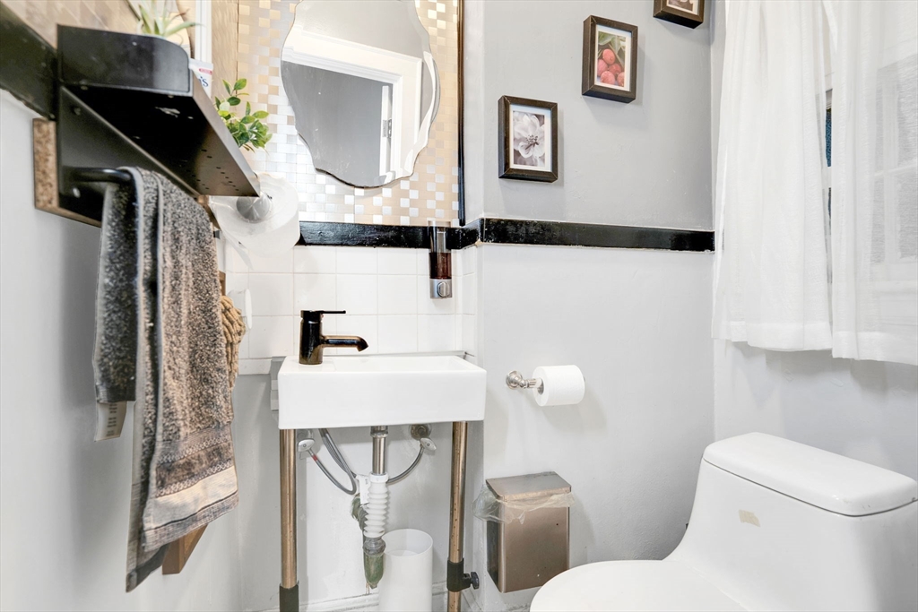 39 Range Road Boston, MA 02124 - Photo 4 of 25 a bathroom with a sink and mirror with toilet