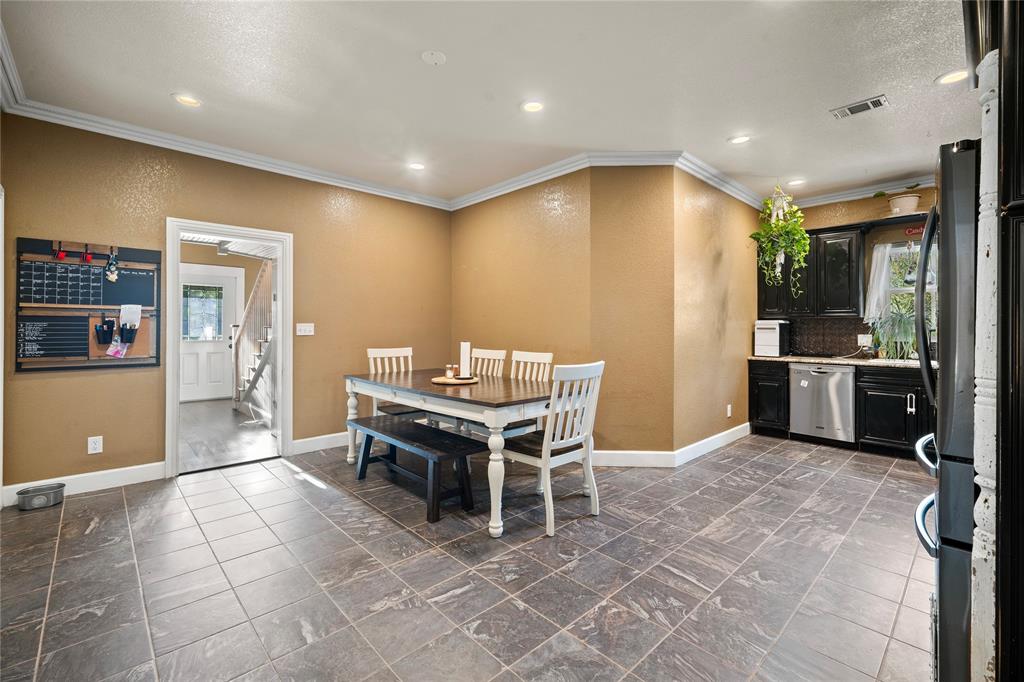 202 North Kickapoo Street Lipan, TX 76462 - Photo 7 of 38 Tile flooring, dark wood-finish cabinetry, stainless steel dishwasher, crown molding, and recessed lighting