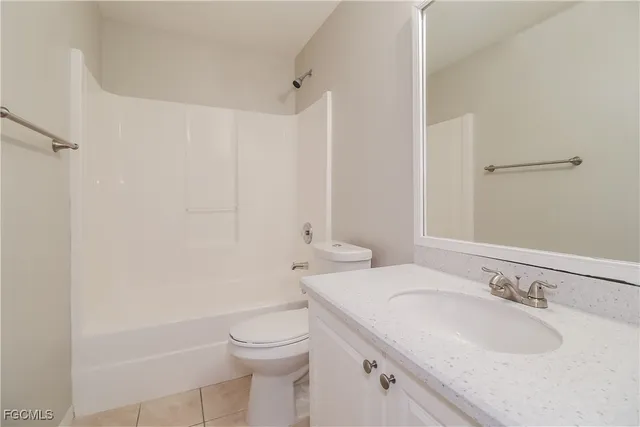 a bathroom with a granite countertop sink a toilet and a bathtub