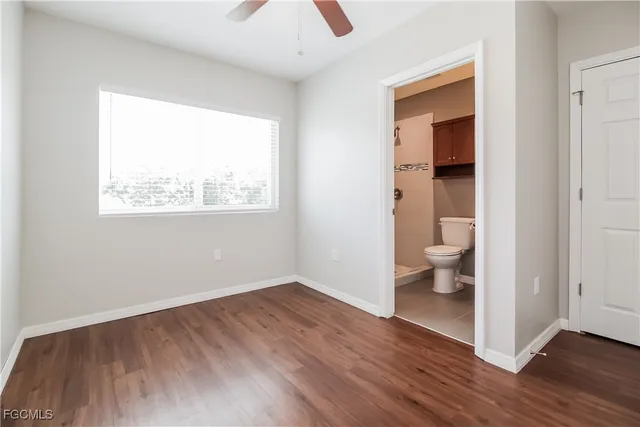 an empty room and a bathroom with sink