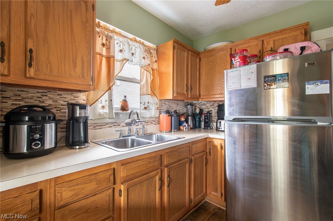 117 Morrison Street Struthers, OH 44471 - Photo 7 of 38 Kitchen with stainless steel refrigerator, tasteful backsplash, sink, and dark hardwood / wood-style floors