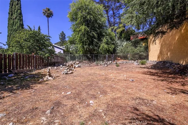 a view of a house with backyard and a tree