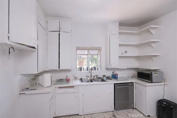 a kitchen with granite countertop a sink stainless steel appliances and cabinets