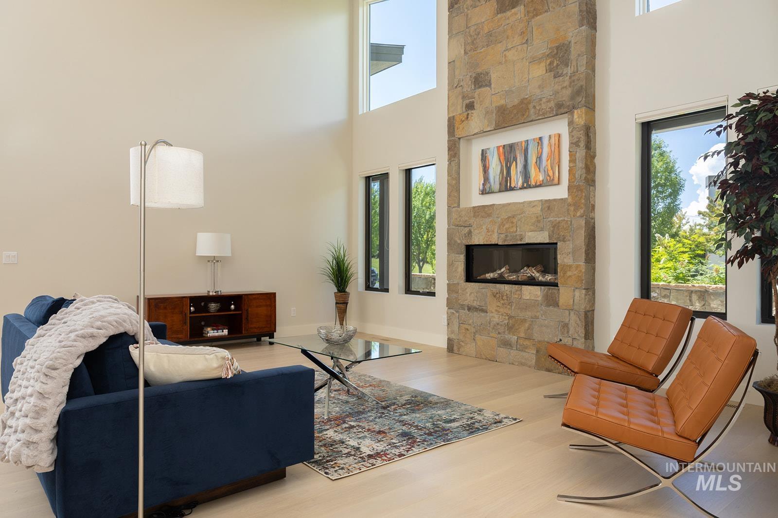 27 Streamside Drive Hailey, ID 83333 - Photo 5 of 39 Living area featuring wood finished floors, a fireplace, and a high ceiling