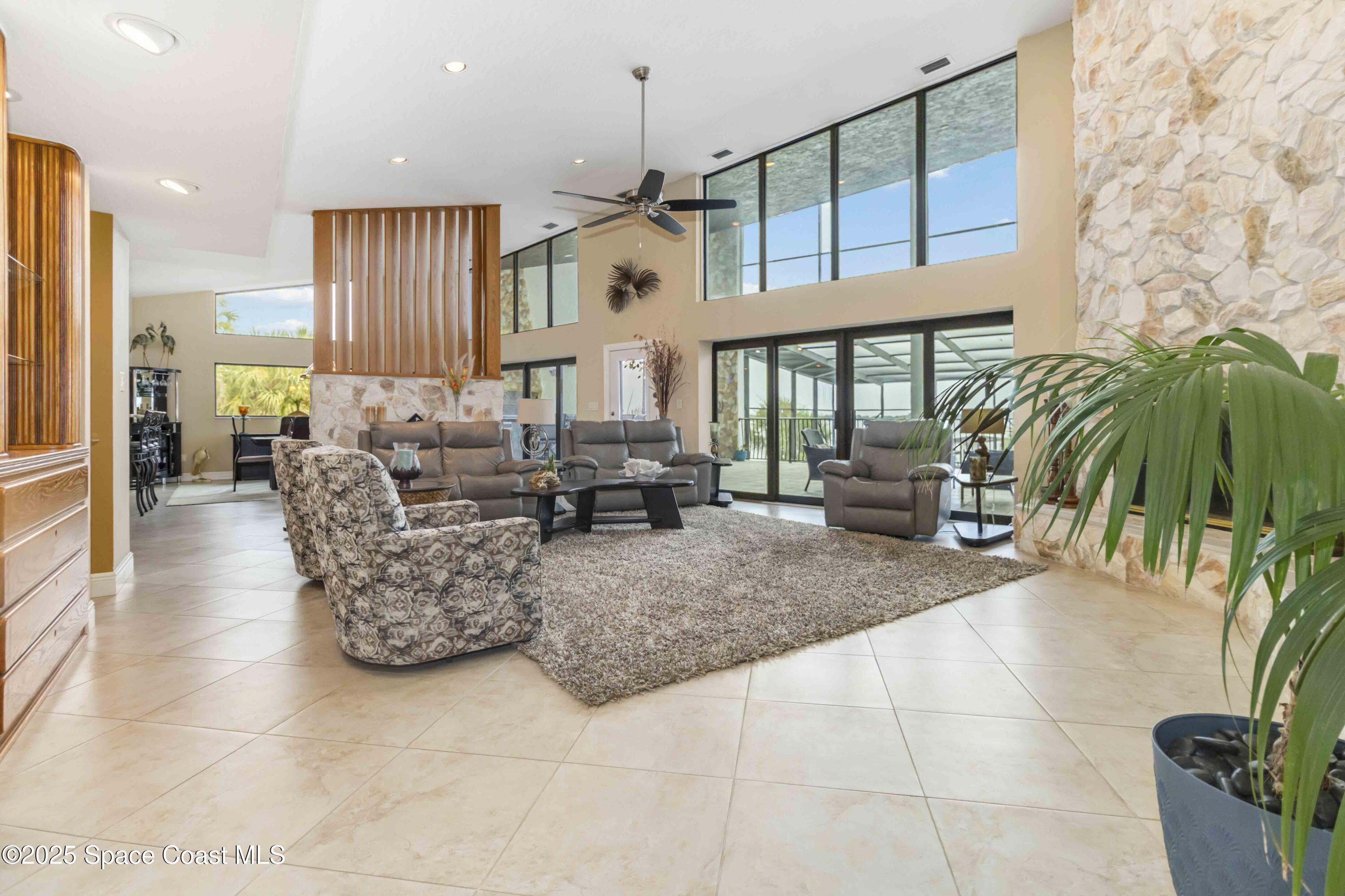 110 Barnacle Place Rockledge, FL 32955 - Photo 7 of 73 a living room with furniture a chandelier and a floor to ceiling window