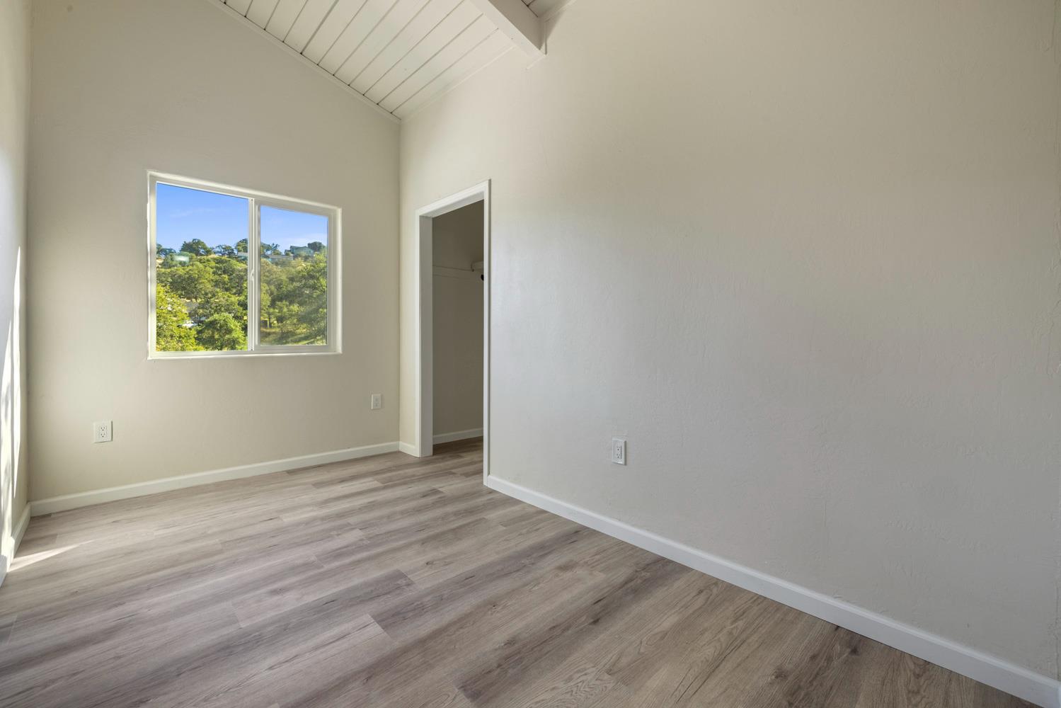 2324 Quail Hill Road Copperopolis, CA 95228 - Photo 33 of 52 an empty room with wooden floor and windows