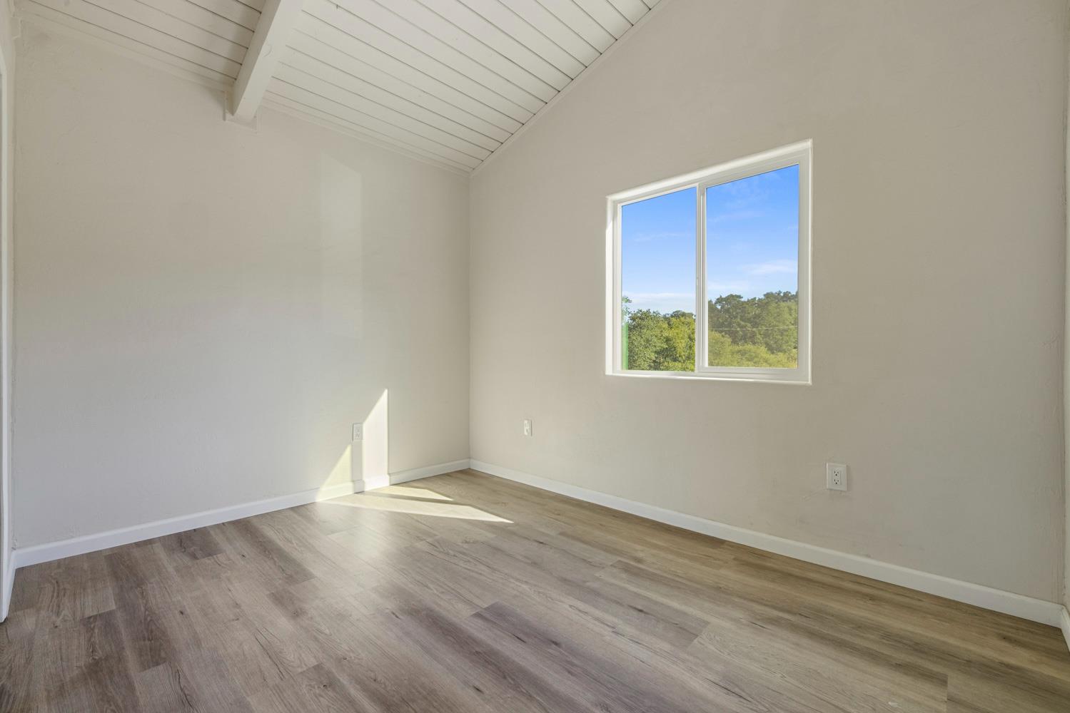2324 Quail Hill Road Copperopolis, CA 95228 - Photo 35 of 52 an empty room with wooden floor and windows
