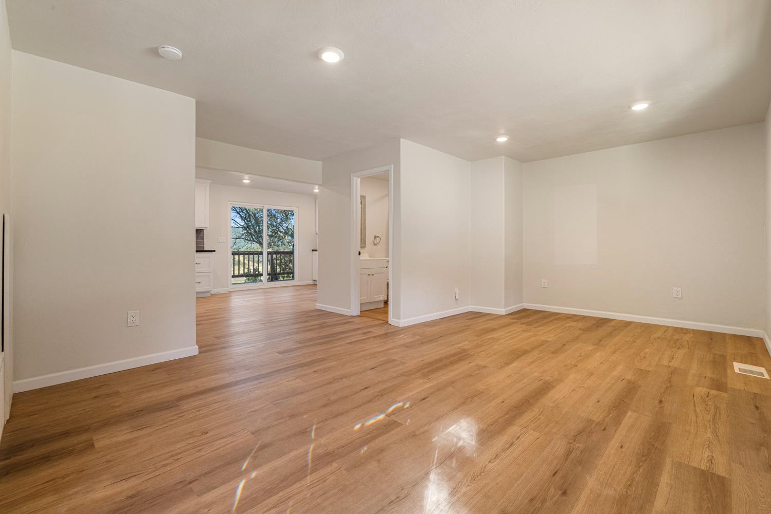 2324 Quail Hill Road Copperopolis, CA 95228 - Photo 5 of 52 an empty room with wooden floor and natural light