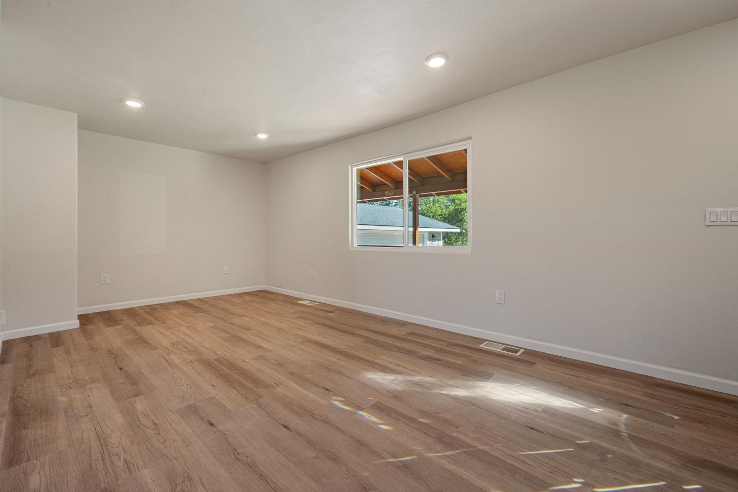 2324 Quail Hill Road Copperopolis, CA 95228 - Photo 6 of 52 an empty room with window and wooden floor