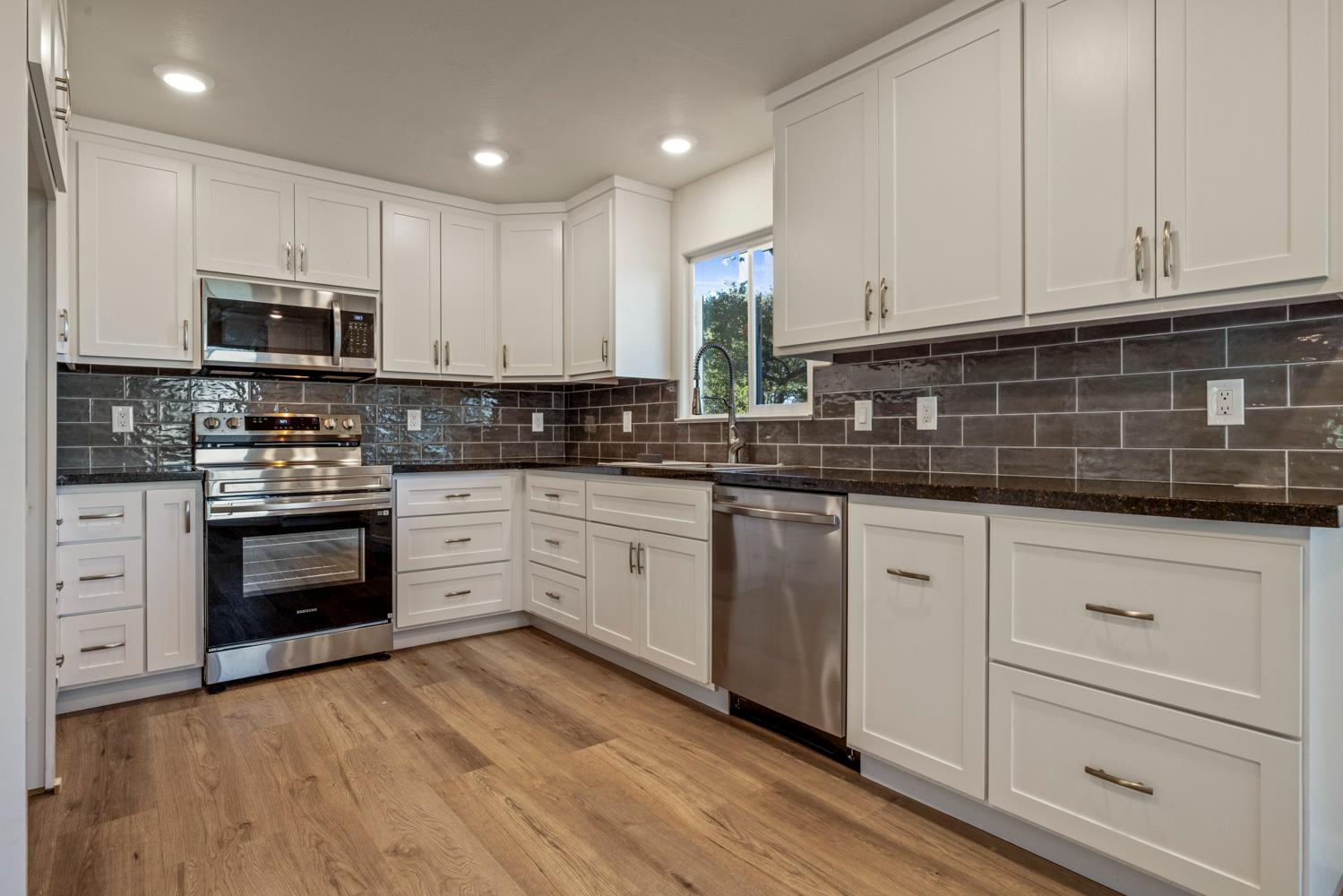 2324 Quail Hill Road Copperopolis, CA 95228 - Photo 10 of 52 a kitchen with granite countertop white cabinets and stainless steel appliances