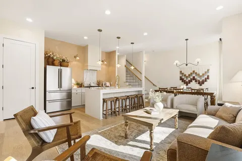 a living room with fireplace furniture and kitchen view