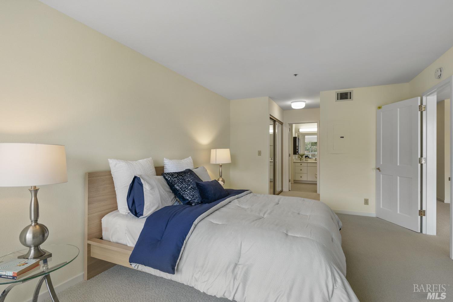 100 Thorndale Drive, Unit 303 San Rafael, CA 94903 - Photo 14 of 32 a bedroom with a bed and a lamp