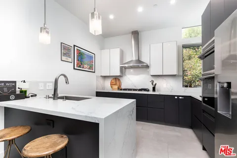 a kitchen with stainless steel appliances a sink stove and microwave