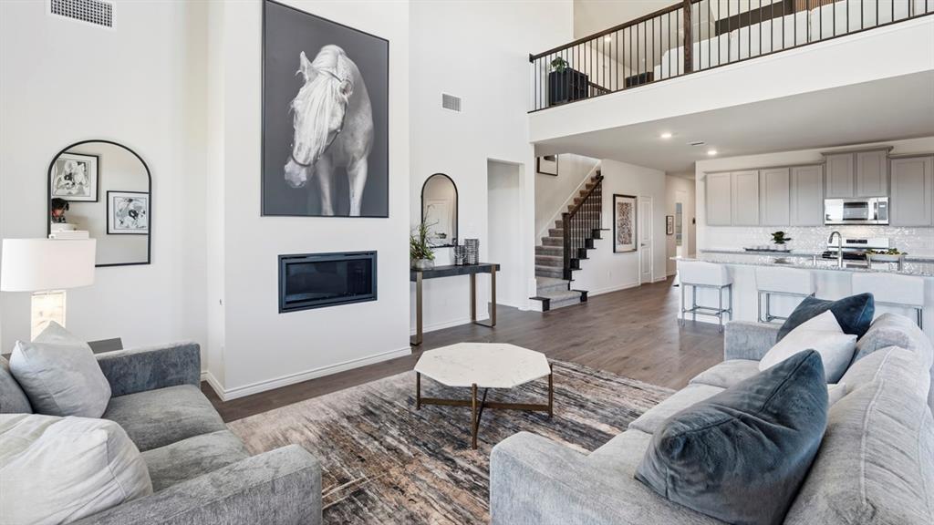 4197 Waldron Trail Forney, TX 75126 - Photo 12 of 25 Open-concept living space featuring high ceilings, a built-in fireplace, and wood-finish flooring