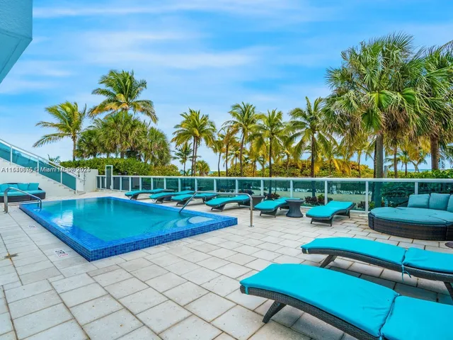 a view of a swimming pool with a lounge chair and potted plants