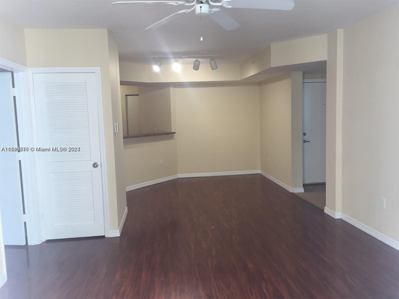 9201 Collins Avenue, Unit 724 Surfside, FL 33154 - Photo 4 of 14 an empty room with wooden floor and a ceiling fan