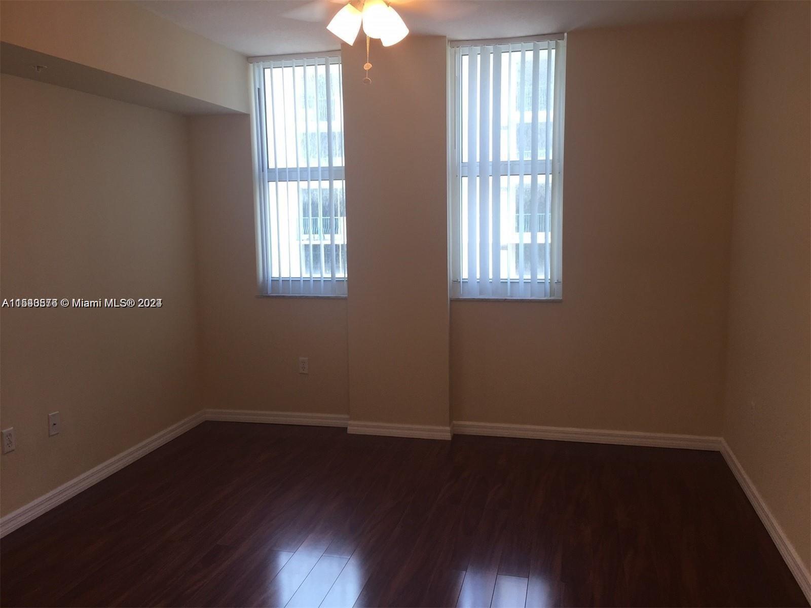 9201 Collins Avenue, Unit 724 Surfside, FL 33154 - Photo 5 of 14 a view of an empty room with wooden floor and a window