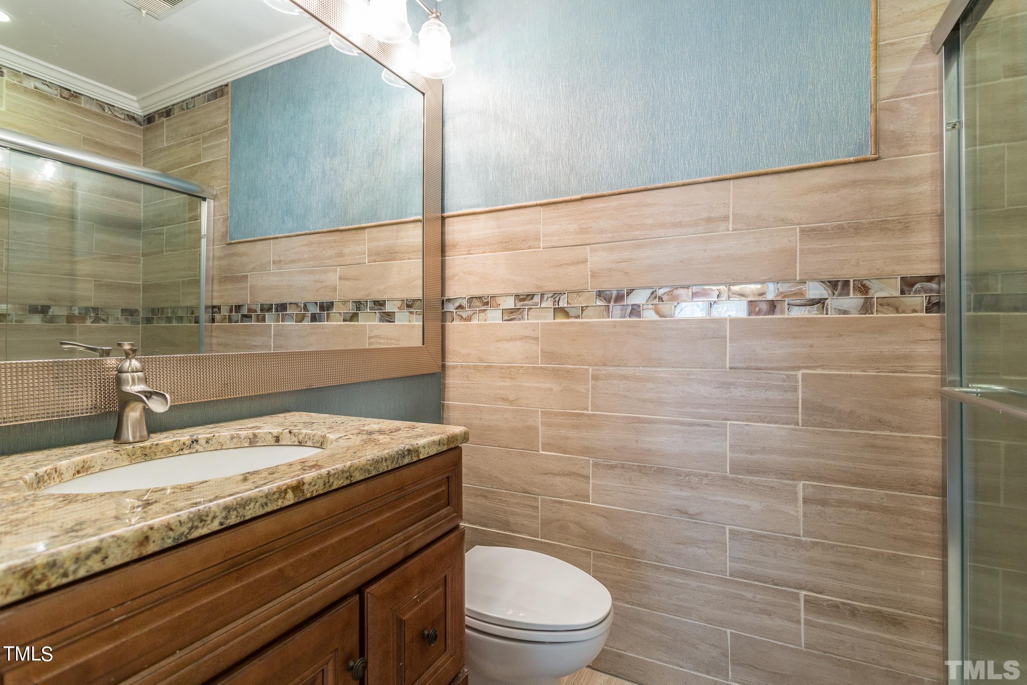 4424 Roller Court Raleigh, NC 27604 - Photo 19 of 19 a bathroom with a granite countertop toilet sink and mirror