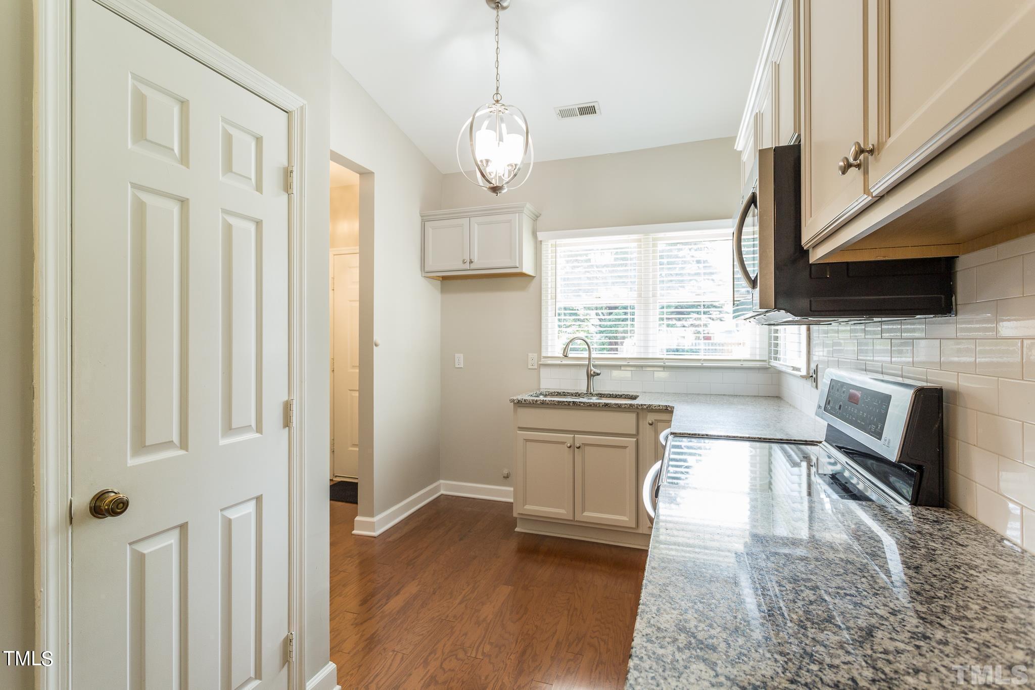 4424 Roller Court Raleigh, NC 27604 - Photo 9 of 19 a open kitchen with a sink a microwave and cabinets